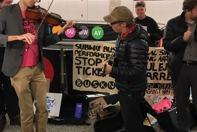 Buskers Matthew Christian and Marc Orleans perform during a protest at the 72nd Street Second Avenue Subway stop.